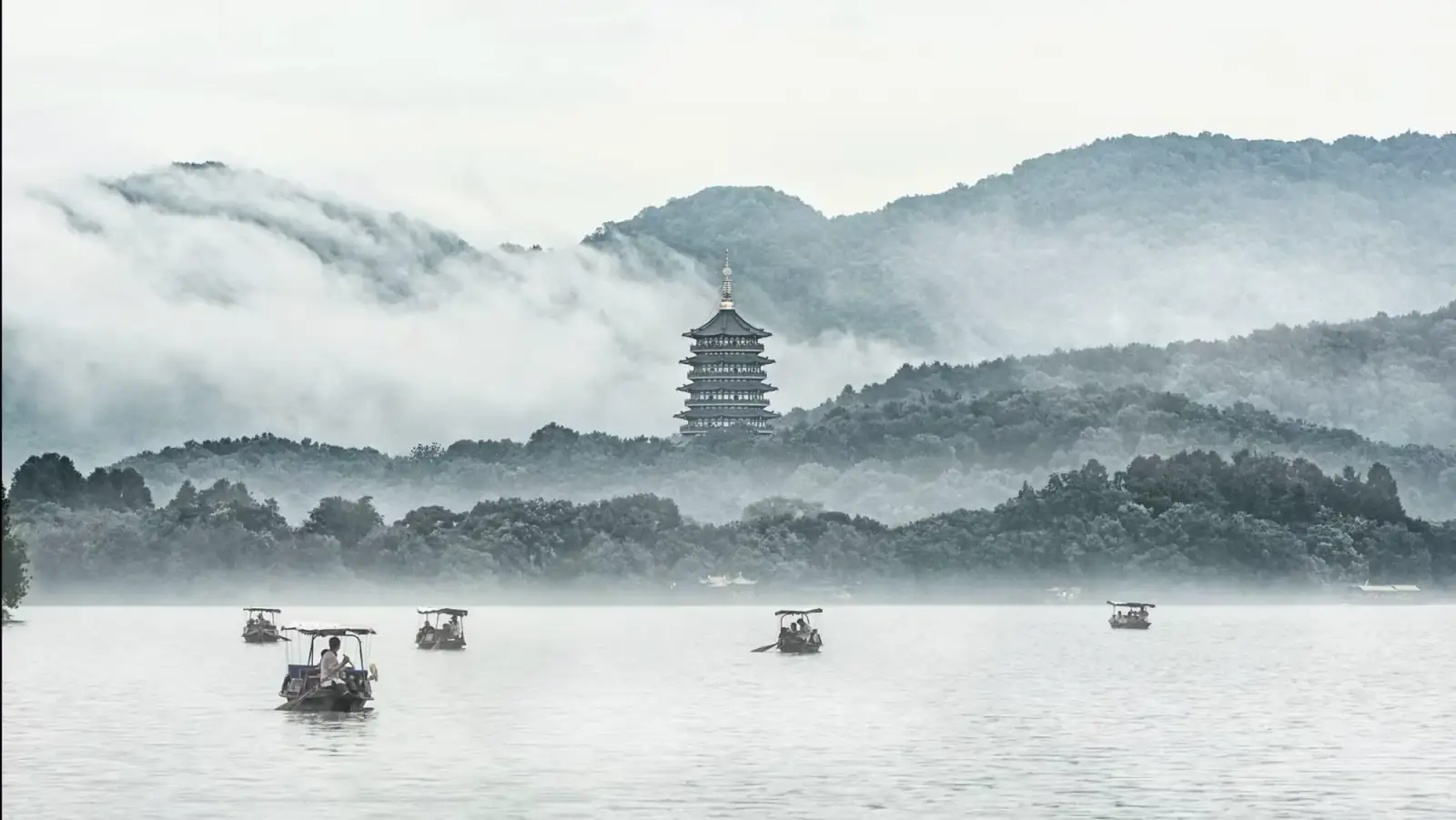 Misty West Lake with Leifeng Pagoda and boats in Hangzhou